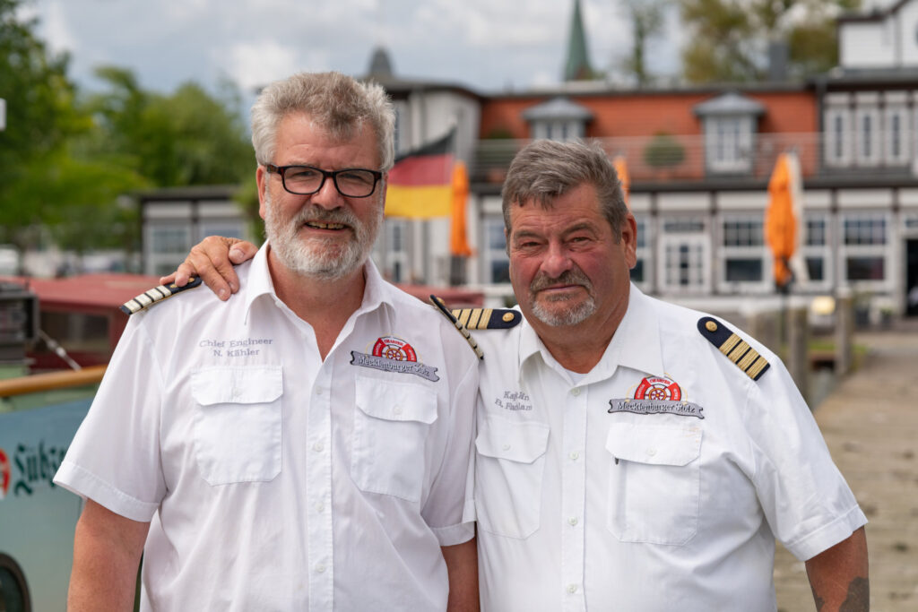 Unsere zwei Schiffsführer Norbert und Bernd in Uniform vor dem Ausflugsschiff Mecklenburger Stolz